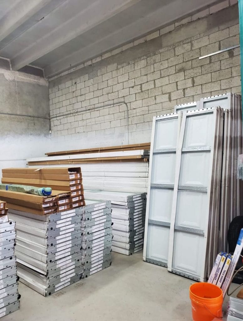 New garage door panels and wood trim stacked in a garage
